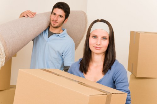 Local removals team handling furniture outside a Colliers Wood property